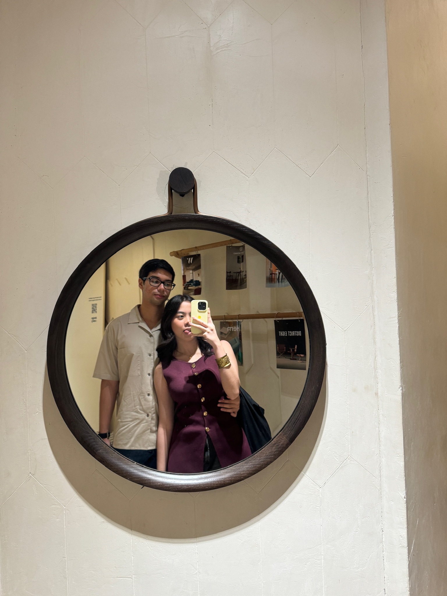 Pia and Zach smiling together in a gallery mirror